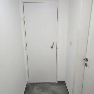 דלת לבנה עם ידית מתכת ומנעול