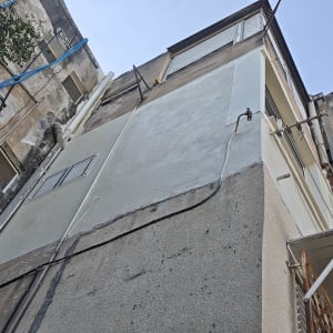 עבודת תיקוני טיח ושיקום בטון בחזית בניין בגובה