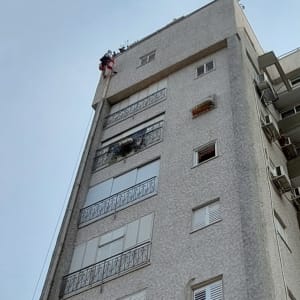 אדם מטפס על בניין גבוה באמצעות חבלים