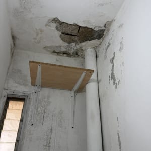קיר ותקרה עם נזקי רטיבות קשים ועובש לפני עבודת שיקום וצביעה