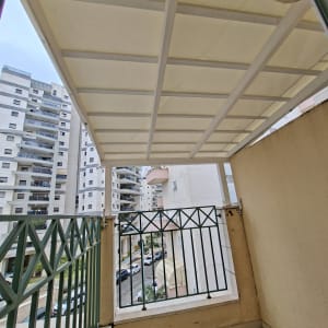 מרפסת עם גג עץ ומעקה ברזל