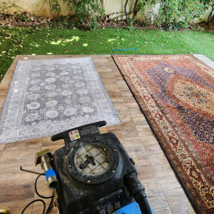 מכונת ניקוי שטיחים על דק עץ עם שטיחים צבעוניים