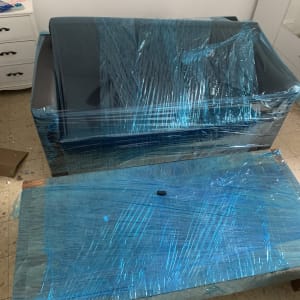 ספה ושולחן עטופים בניילון כחול למעבר דירה