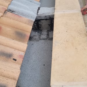 רעפים חומים על גג עם שכבת איטום אפורה