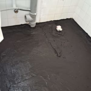 רצפה אטומה עם חומר איטום שחור וצינורות