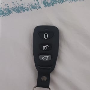 שלט רכב עם שלושה כפתורים על רקע בד לבן