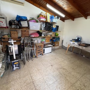 חדר עם ציוד וכלים שונים, מדפים עם קופסאות וארגזים