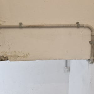 צינור חשמל מותקן על קיר לבן עם חיבורים