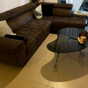 ספה חומה עם כריות על רצפת אריחים