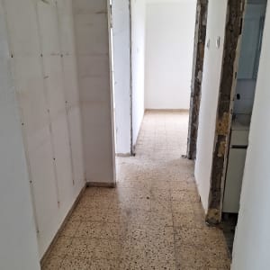 מסדרון עם קירות לבנים ורצפת אריחים