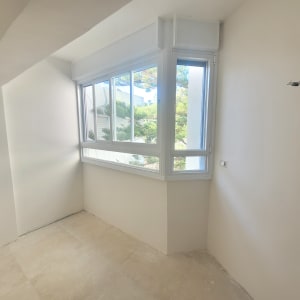 חלון אלומיניום עם מסגרת לבנה בחדר מואר