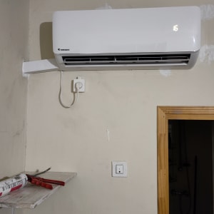 מזגן מותקן על קיר עם תצוגת טמפרטורה דולקת