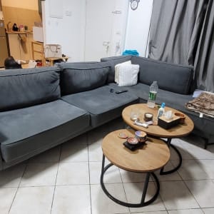 סלון עם ספה, שולחנות קטנים וגיטרה בפינה