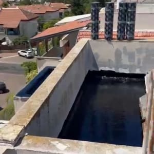 גג עם יריעות איטום שחורות על משטח בטון
