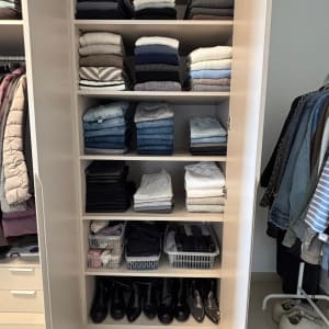 ארון בגדים מסודר עם בגדים מקופלים ונעליים