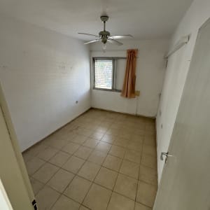 חדר ריק עם מאוורר תקרה ורצפת אריחים