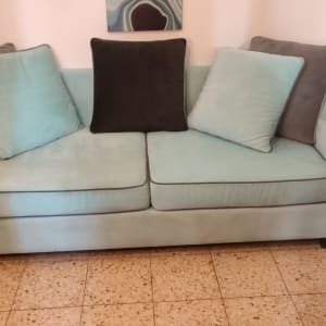 ספה עם כריות בצבעים שונים על רצפת אריחים