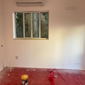 פחית צבע על יריעת פלסטיק אדומה בחדר