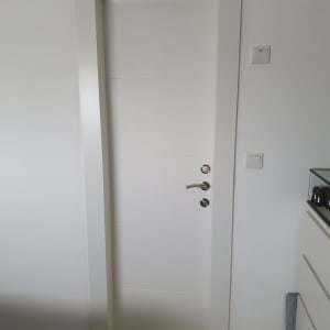 דלת לבנה עם ידית מתכת כסופה