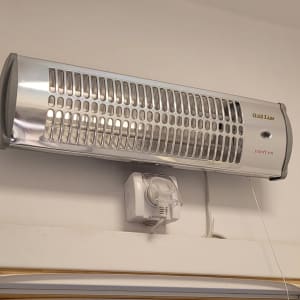 תנור חימום חשמלי מותקן על קיר עם חוט חשמל