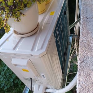 יחידת מזגן חיצונית מותקנת על קיר עם צינורות