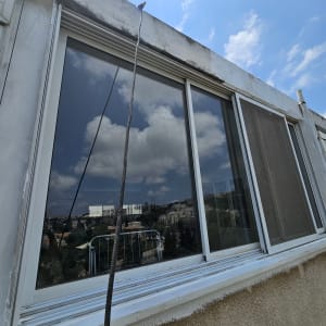 חבל תלוי ליד חלון בניין גבוה בשמיים כחולים