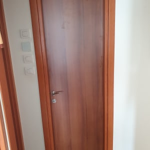 דלת עץ חומה עם ידית מתכת כסופה