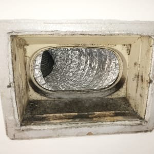 פתח אוורור עם צינור מתכת גלי ומסגרת מלוכלכת