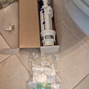 חלקי אסלה באריזה על רצפת חדר אמבטיה