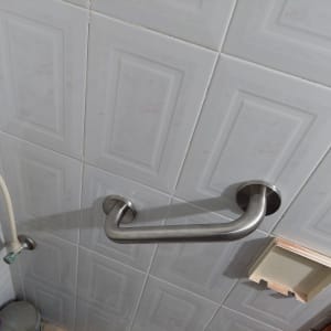 ידית אחיזה מתכתית מותקנת על קיר אריחים