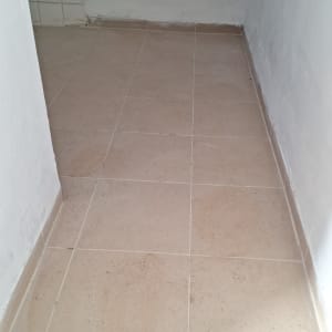 רצפה מרוצפת עם כיור תלוי על הקיר