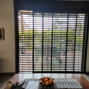 תריסי אלומיניום שחורים על חלון גדול