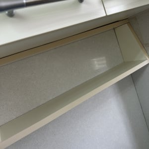 מדף נקי מתחת לארון מטבח עם ידיות מתכת