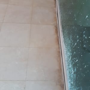 רצפה מלוכלכת ליד חלון עם כתמי מים