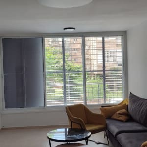 חלון עם תריסי אלומיניום בסלון מואר