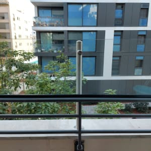 מעקה זכוכית עם עמודי מתכת במרפסת