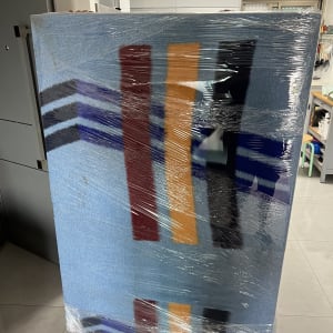 רהיט בודד עטוף בשמיכת הובלה וניילון נצמד על עגלת סבלים
