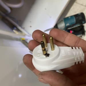 תקע חשמלי עם סימני שריפה ביד חשמלאי