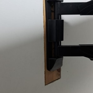 זרוע מתכת שחורה מותקנת בקיר לבן