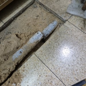 צינור מתכת חשוף בתוך רצפה שבורה