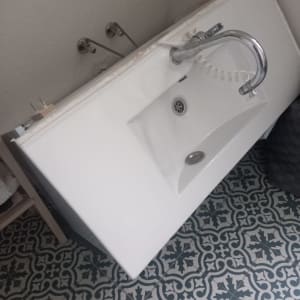 כיור מונח על הרצפה עם ברז מחובר