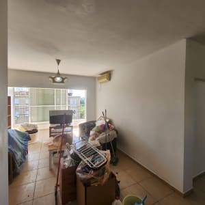 קיר צבוע בלבן עם כלי ניקוי על הרצפה