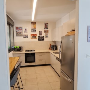 מטבח מודרני עם מקרר, תנור וכיסאות בר