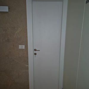 דלת לבנה עם ידית מתכת ומנעול