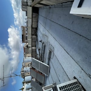 גג עם יריעות איטום אפורות ומתקנים שונים