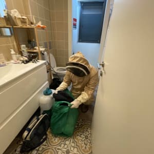 אדם בחליפת מגן עם ציוד הדברה בחדר אמבטיה