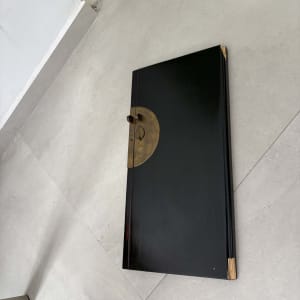 לוח עץ שחור עם פינה שבורה על הרצפה