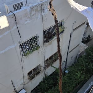 אדם בעבודת גובה עם חבל על בניין