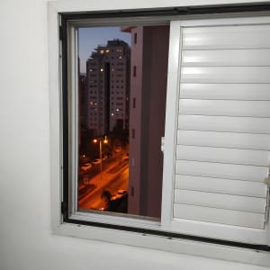 חלון פתוח עם תריסים לבנים