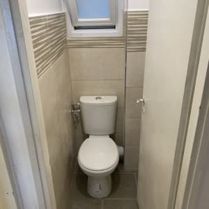 שירותים עם אריחים חדשים וחלון קטן